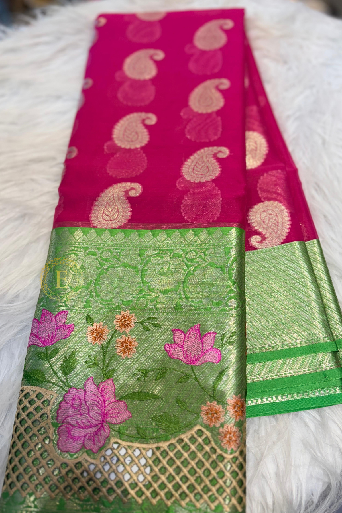 Rani pink semi Banarasi georgette saree with golden paisley buttas and a green Kanchi-style border featuring gold zari and floral embroidery by Ekira.
